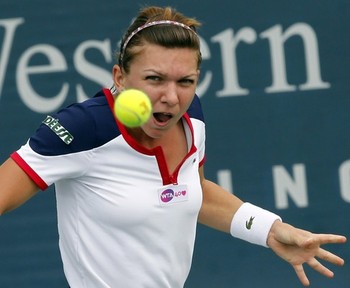 Simona Halep hits a return to Su-Wei Hsieh during their first round match at the women's Cincinnati Open tennis tournament